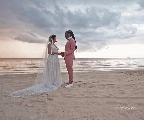 A couple is holding hands on the beach