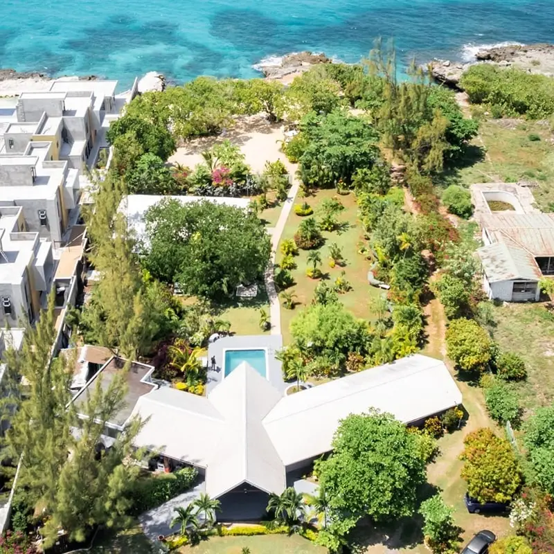 A bird 's eye view of an island with a pool and a house.