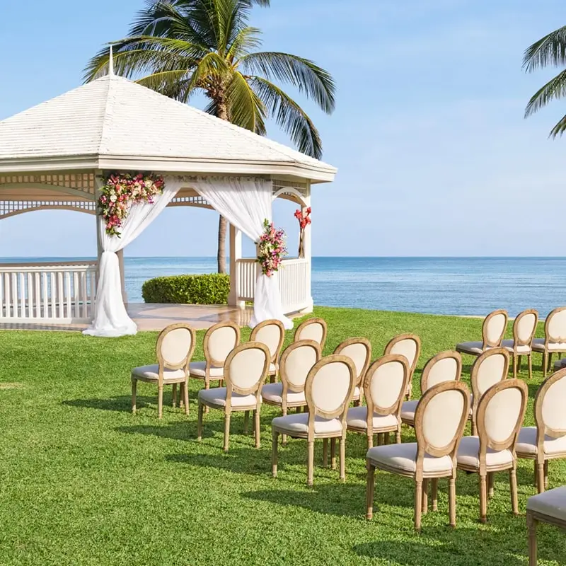 A wedding ceremony with chairs in the grass.