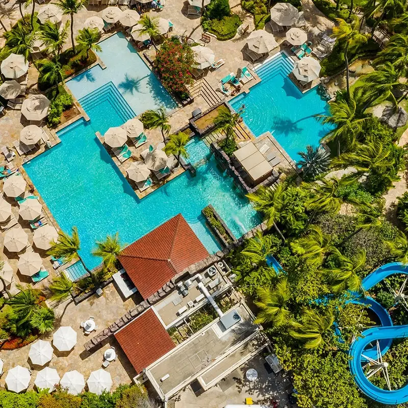 A resort pool with umbrellas and chairs.