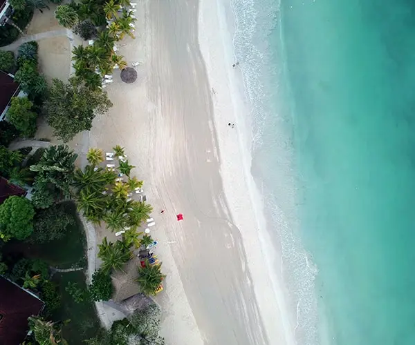 A beach with people swimming in the water.