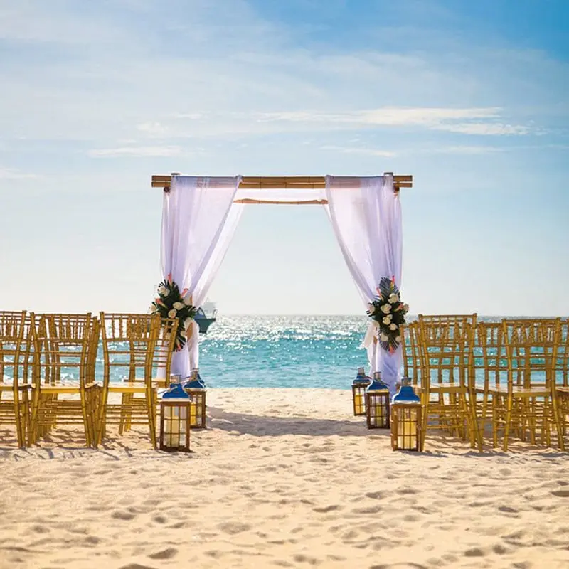 A beach with chairs and an arch on the sand