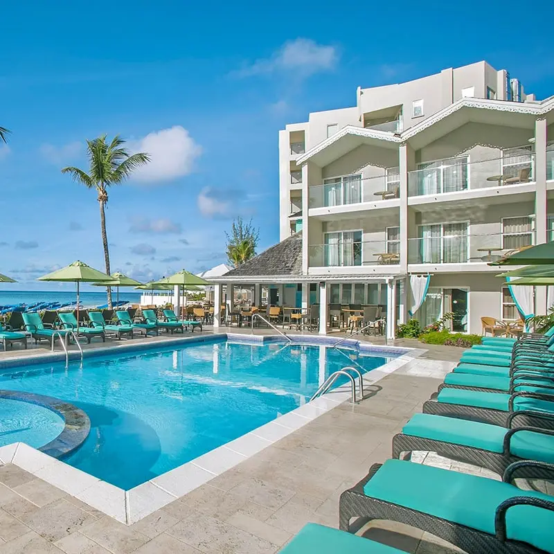 A pool with chairs and umbrellas in front of it.