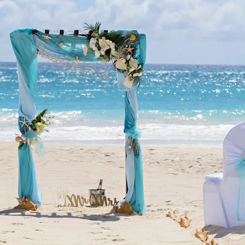 A wedding arch on the beach with flowers