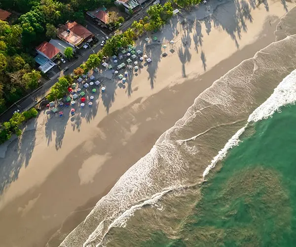 A beach with many people on it and waves coming in