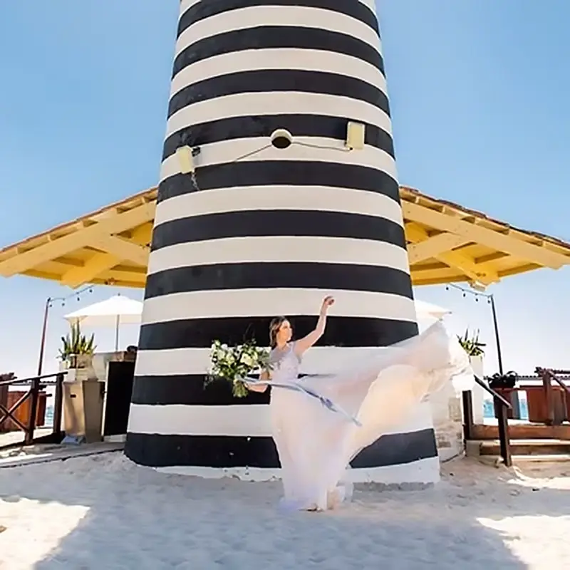 A woman in white dress throwing a frisbee.