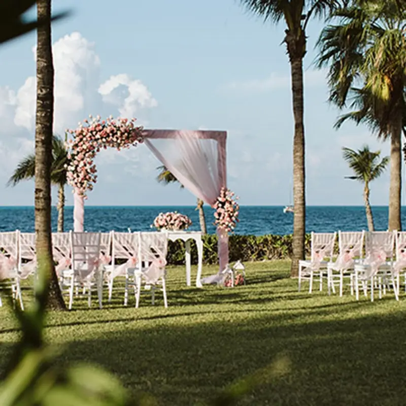 A wedding ceremony with chairs and an arch.