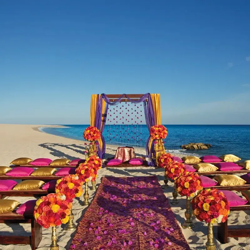 A beach wedding with purple and orange flowers