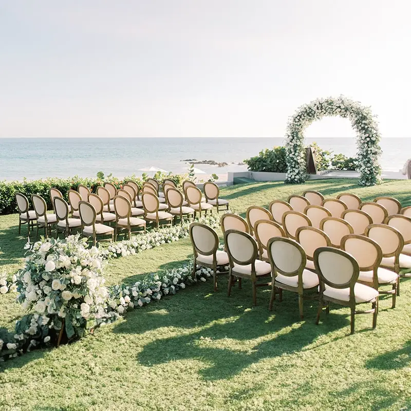 A wedding ceremony with chairs and flowers in the grass.