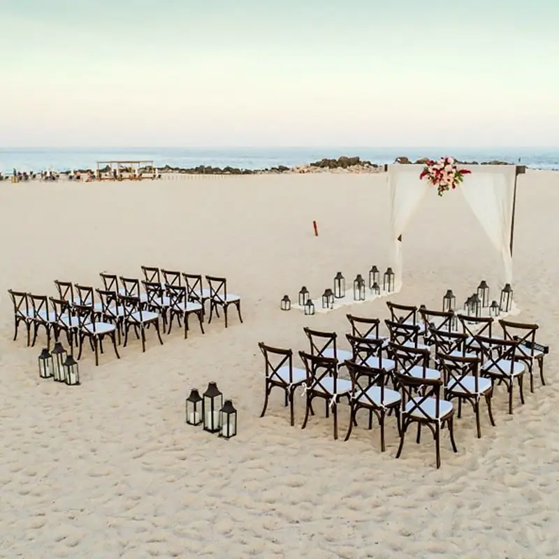 A beach wedding with chairs and tables in the sand