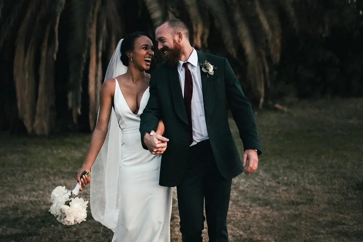 A man and woman walking in the woods.