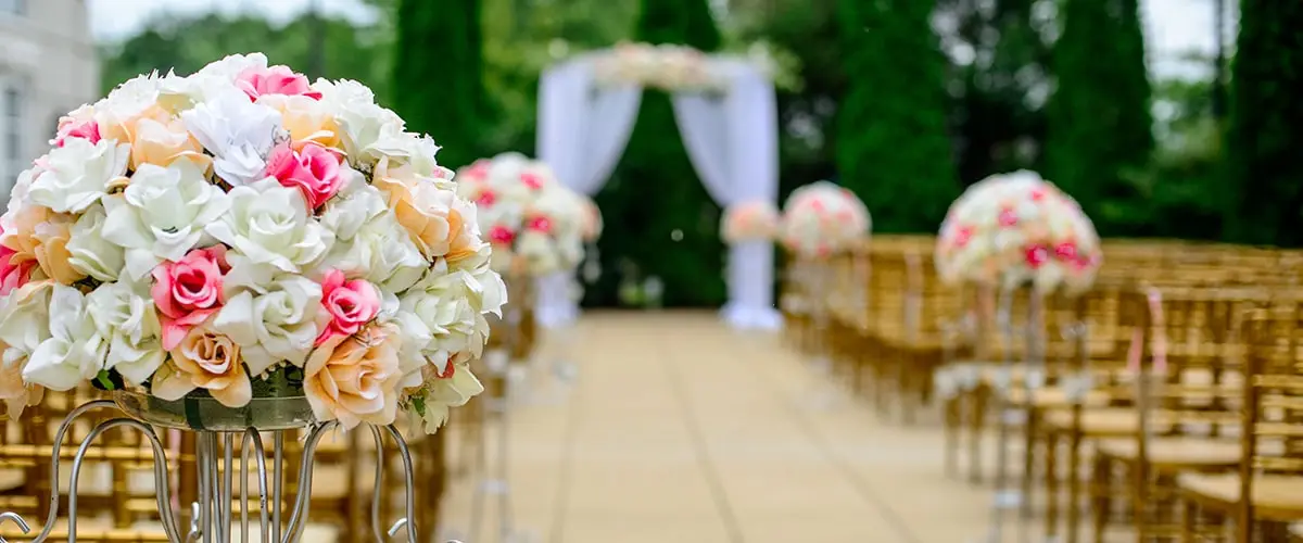 A wedding ceremony with flowers and chairs.