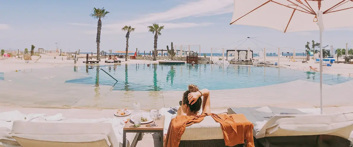 A woman laying on the ground near an outdoor pool.