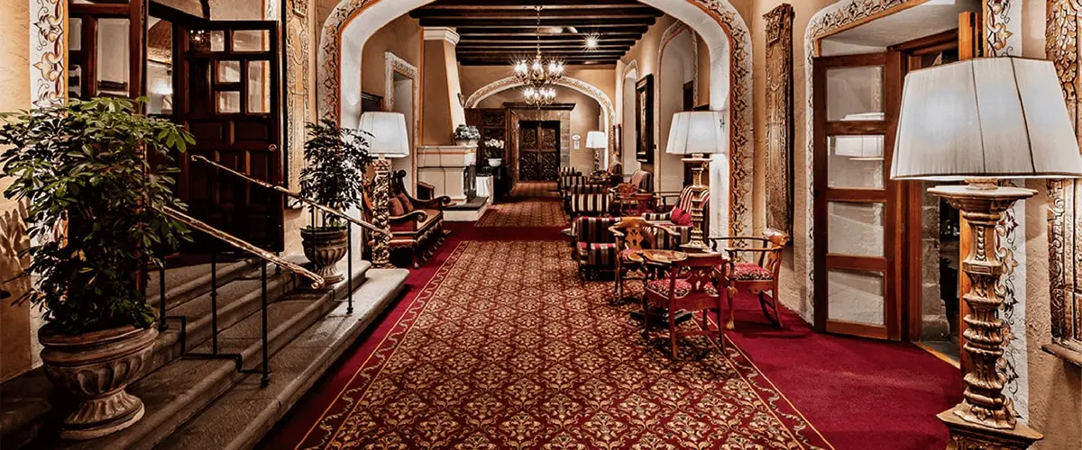 A hotel lobby with red carpet and many chairs.